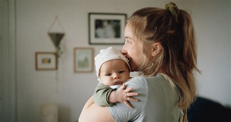 anya mosolyogva tartja a babáját