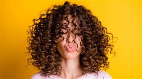 Nő formázza göndör haját