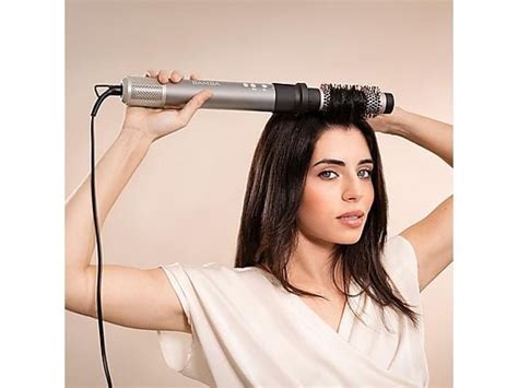 Nő haját formázza hajszárító kefével