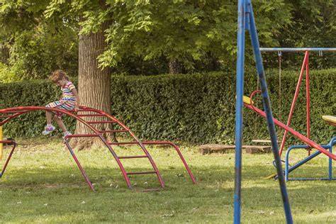 Gyermek játszótéren, ahol a szülők figyelnek a viselkedésére