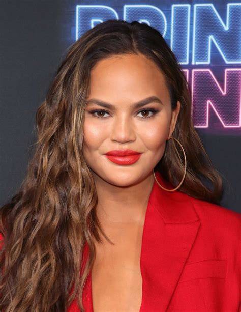 Chrissy Teigen hullámos hosszú frizurája kerek archoz