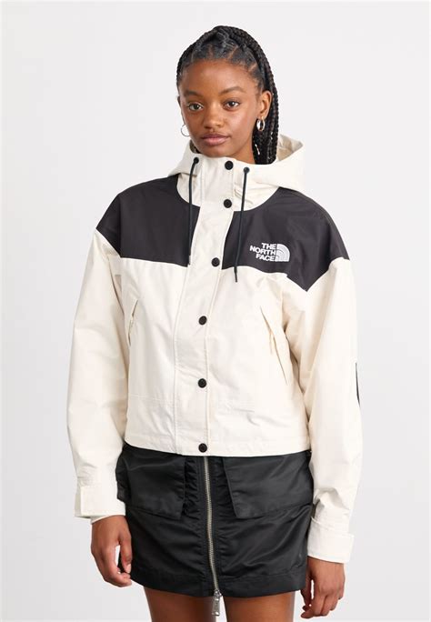Nő túrázik egy The North Face kabátban hegyvidéken